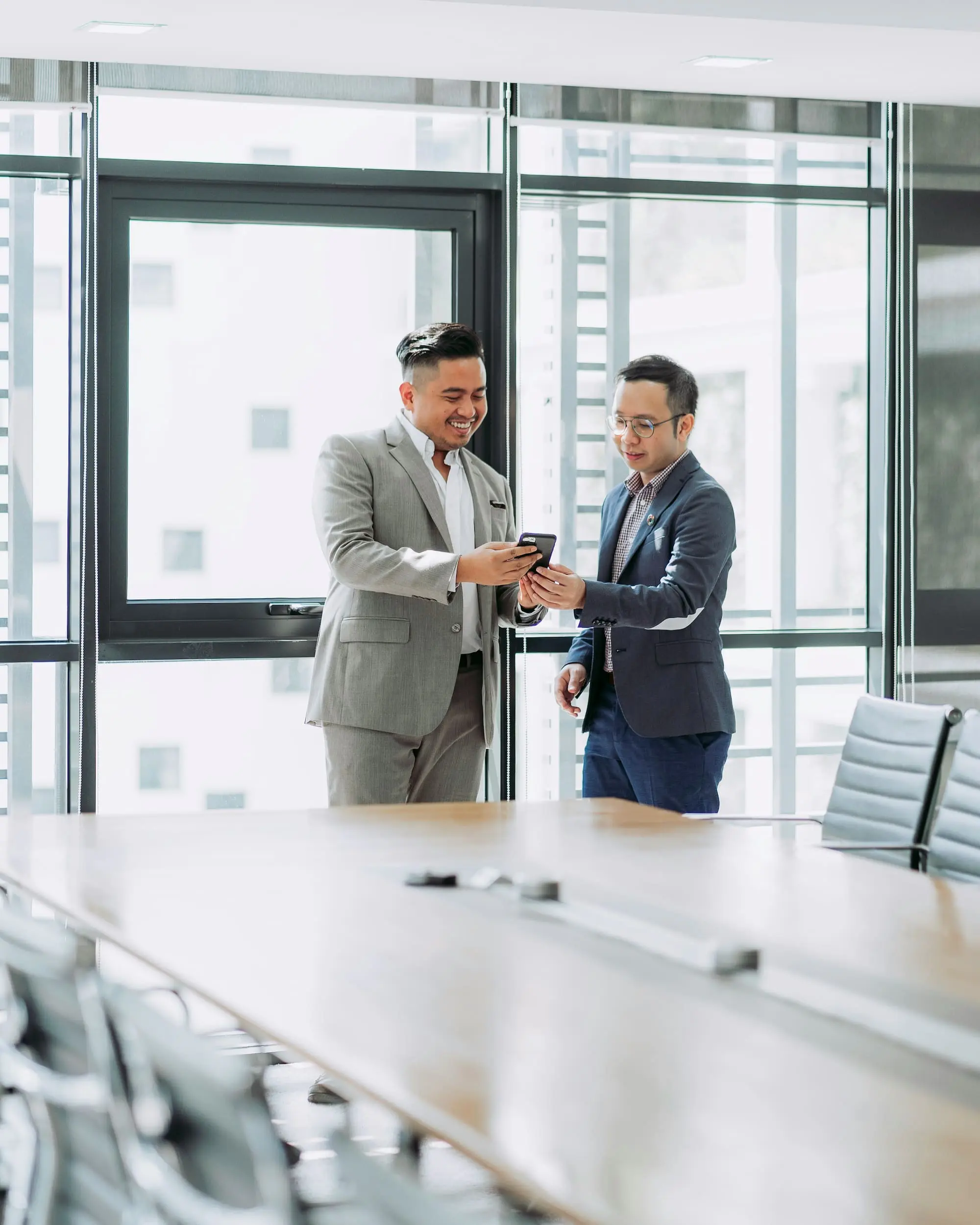 Zwei Geschäftsleute besprechen im Büro digitale Informationen zur Unternehmensnachfolge im Mittelstand